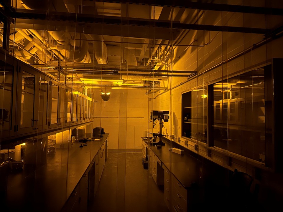 A scientific lab is lit with an extreme amber hue.